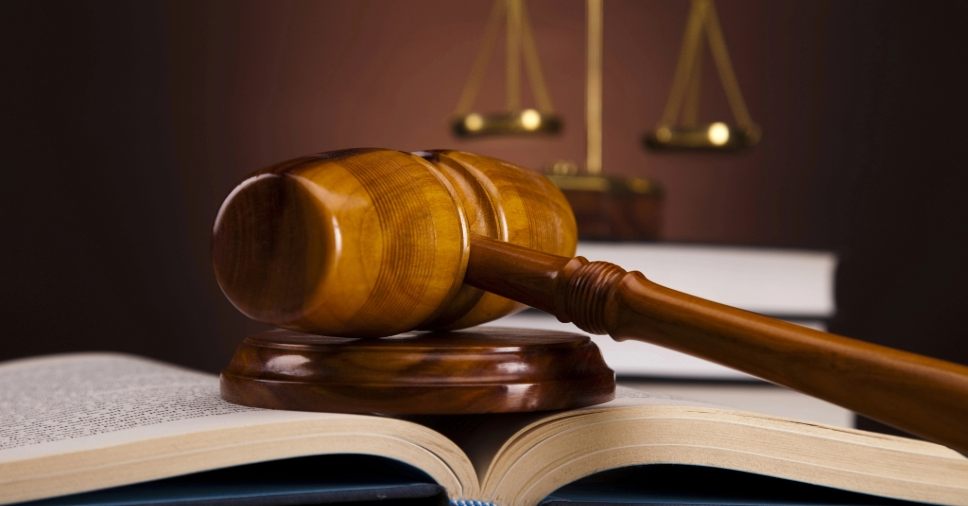 Martelo de juiz em cima de livro com portarias, licenciamentos e leis para construir uma ETA